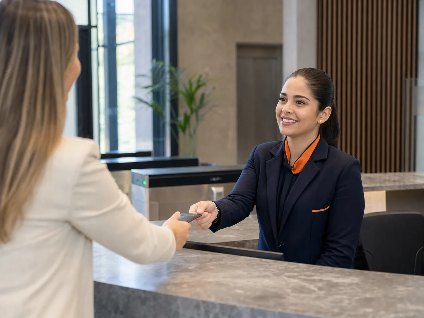 Recepcionista profissional atendendo visitante em ambiente corporativo